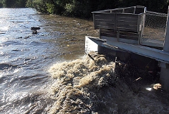 hochwasserführender Fluss kracht gegen Geländer