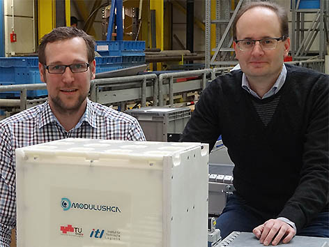 Florian Ehrentraut und Christian Landschützer vom Institut für Technische Logistik der TU Graz mit dem Prototyp der modularen Transportbox aus dem 3D-Drucker