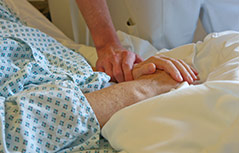 Pfleger hält Hand einer Patientin