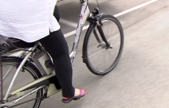 Frau fährt auf E-Bike (Elektrofahrrad)