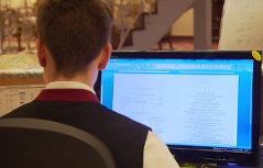 Mitarbeiter an Computerbildschirm in Hotelrezeption